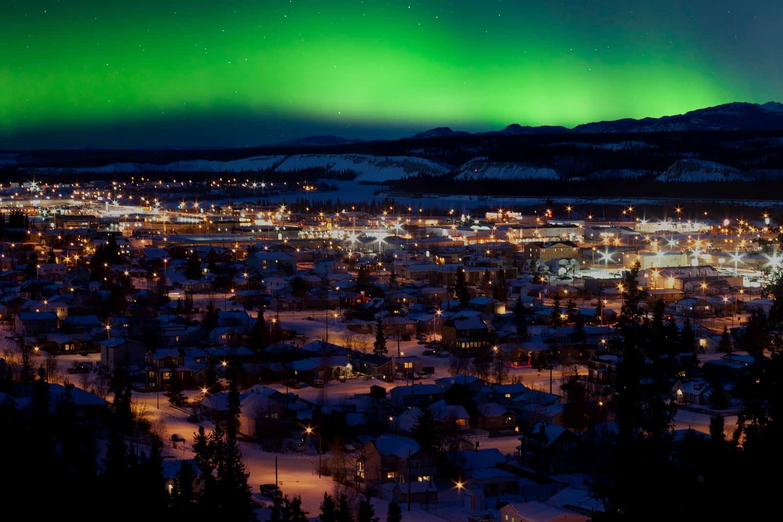 Ein wunderschöner Anblick. Winternacht mit den beeindruckenden Nordlichtern über Downtown Whitehorse. Foto PiLens / Deposit