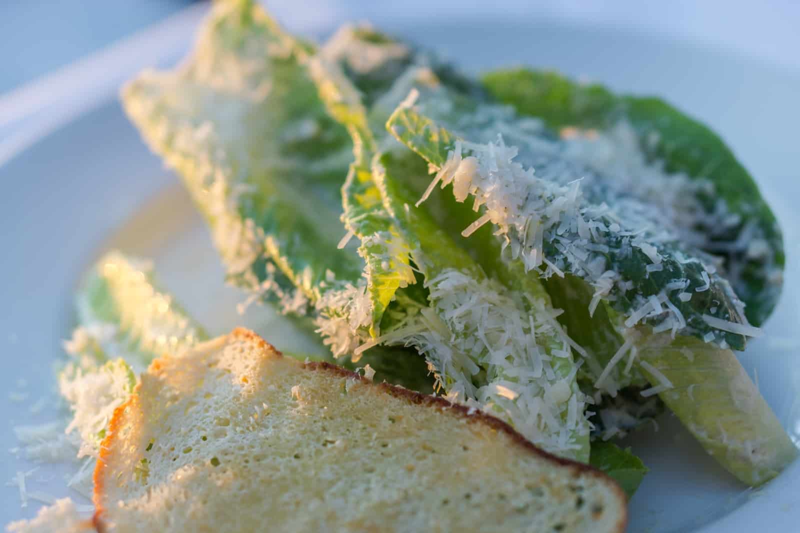 Caesar Salad mit Blättchen vom Grana Padano und Parmesan Crostini. Foto